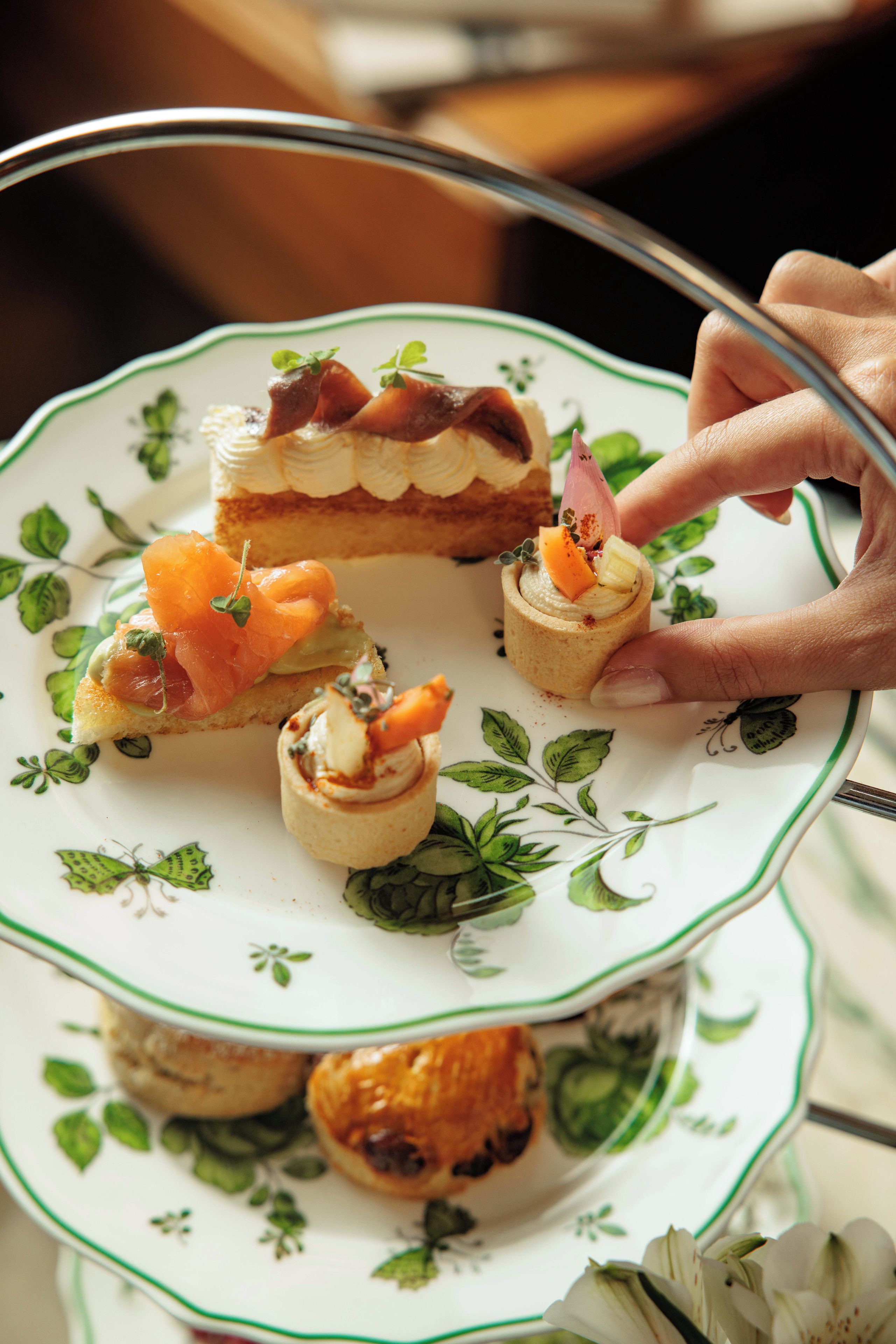 A plate with various food items, including a pastry with cream and a small dish with a garnish.