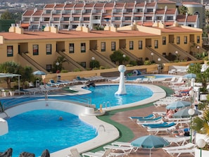 A resort with multiple swimming pools, sun loungers, and a view of hotel buildings in the background. - Laguna Park 1 (Adeje)