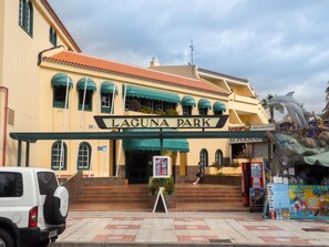 The entrance to Laguna Park with a sign, steps, and a parked car. - Laguna Park 1 (Adeje)