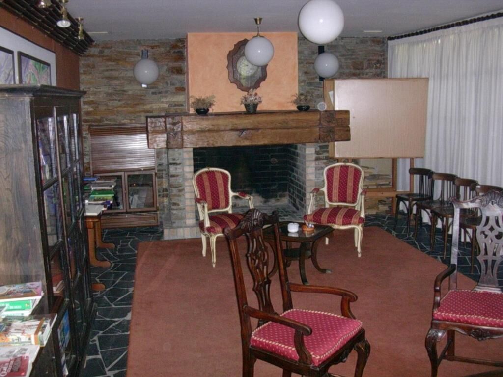 A living room with a fireplace, two armchairs, a coffee table, and a bookshelf.
