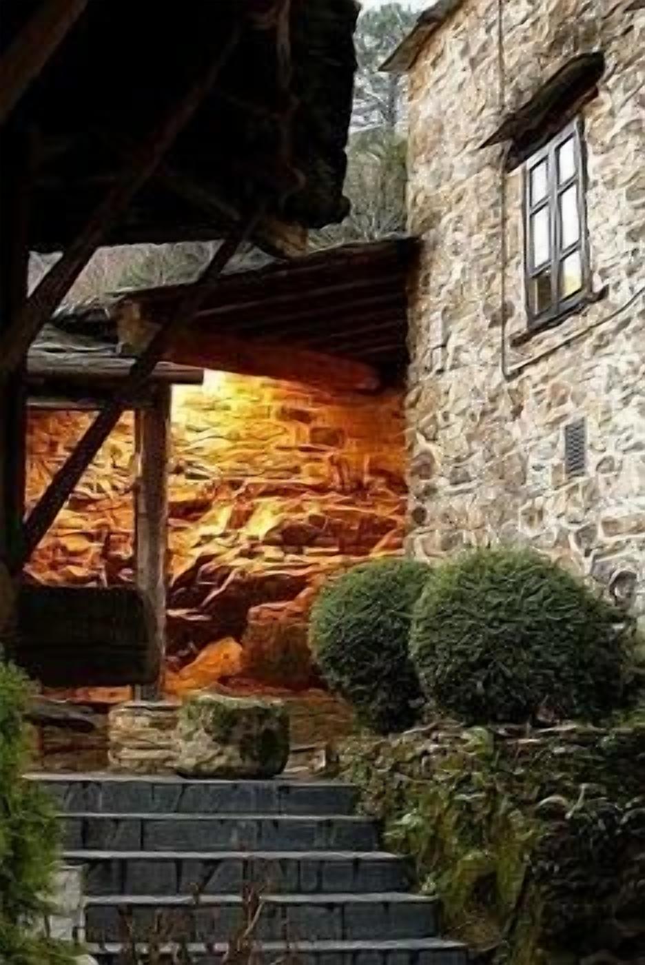 Un bâtiment en pierre doté d’une fenêtre et d’un escalier menant à une structure en bois.