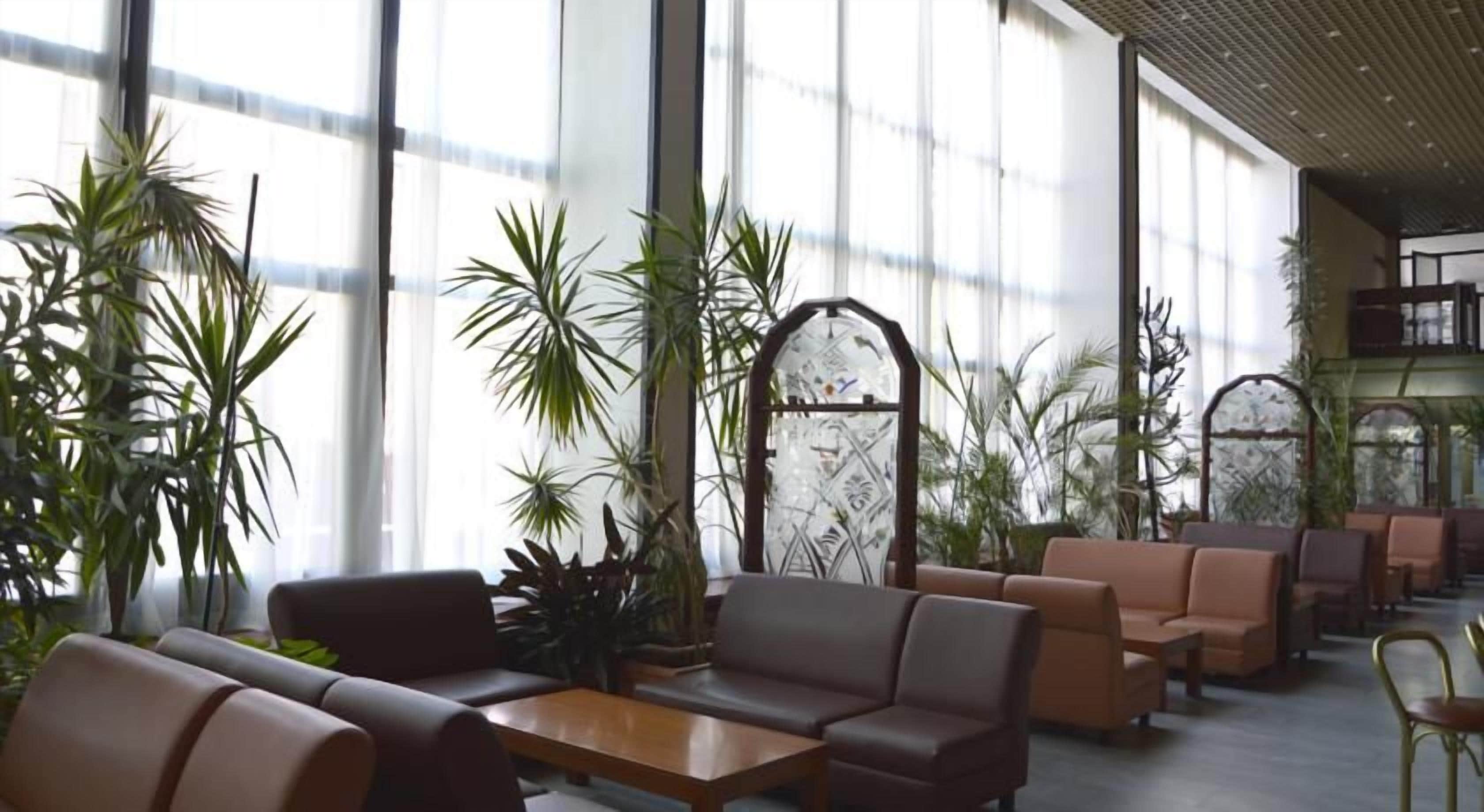 A spacious indoor area with seating arrangements and potted plants.