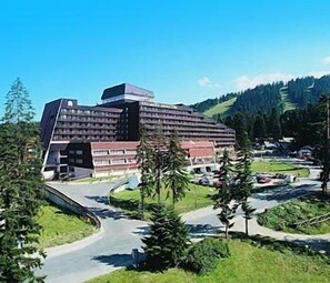 A modern hotel with a unique architectural design, featuring multiple floors and a prominent central structure.