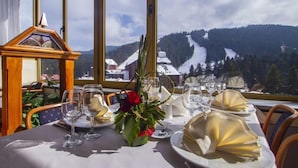 A table set for dining with a view of a snowy mountain landscape. - Hotel Samokov (Samokov)