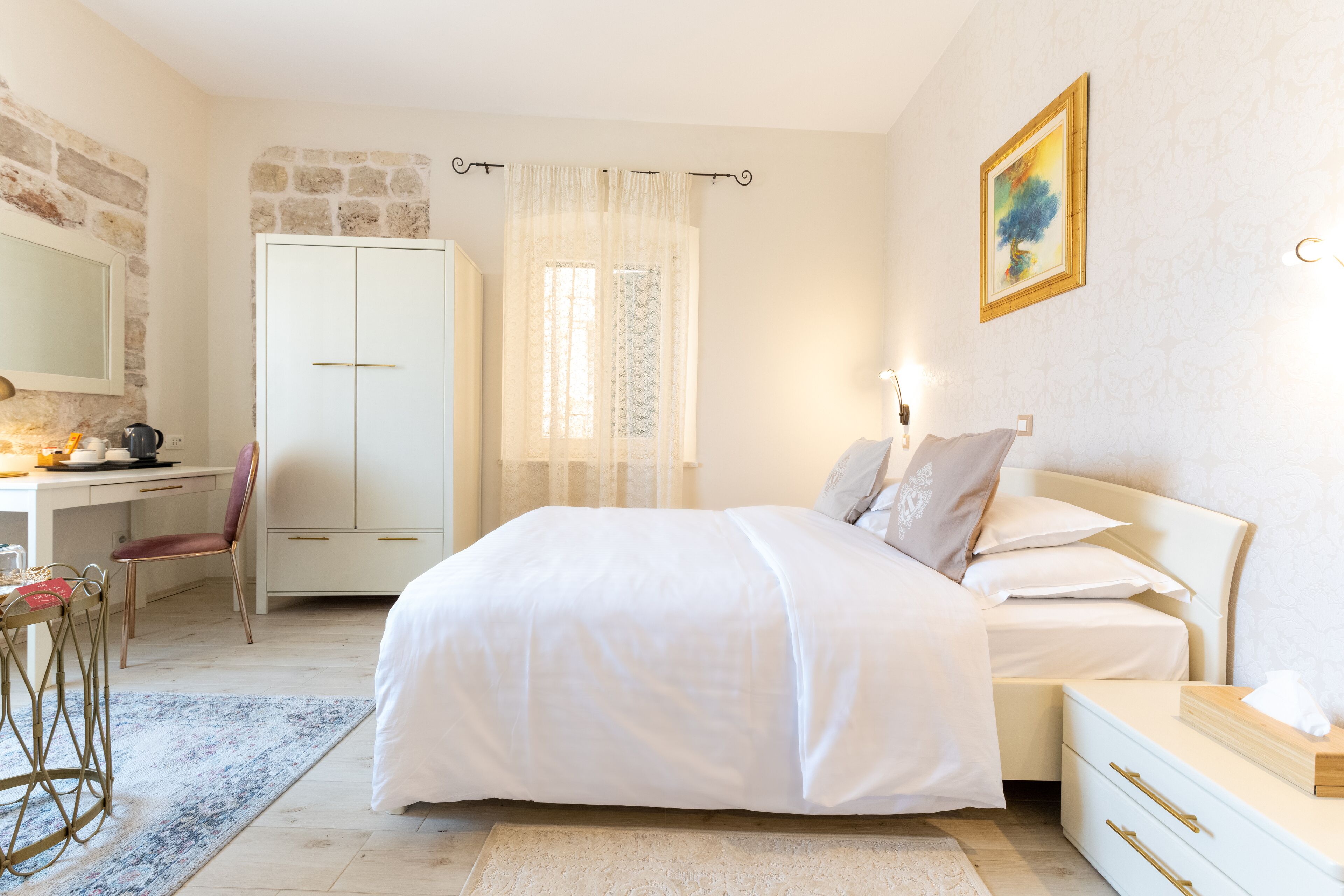 A bedroom with a bed, bedside table, and a desk with a chair.