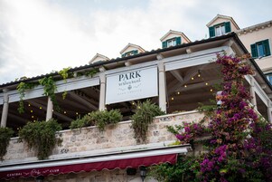 Un restaurante llamado 'Park' con terraza, paredes de piedra y vegetación.
