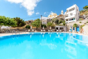 Una piscina al aire libre de temporada, sombrillas