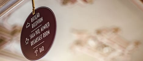 A circular sign with text indicating a reception, breakfast room, and bar.