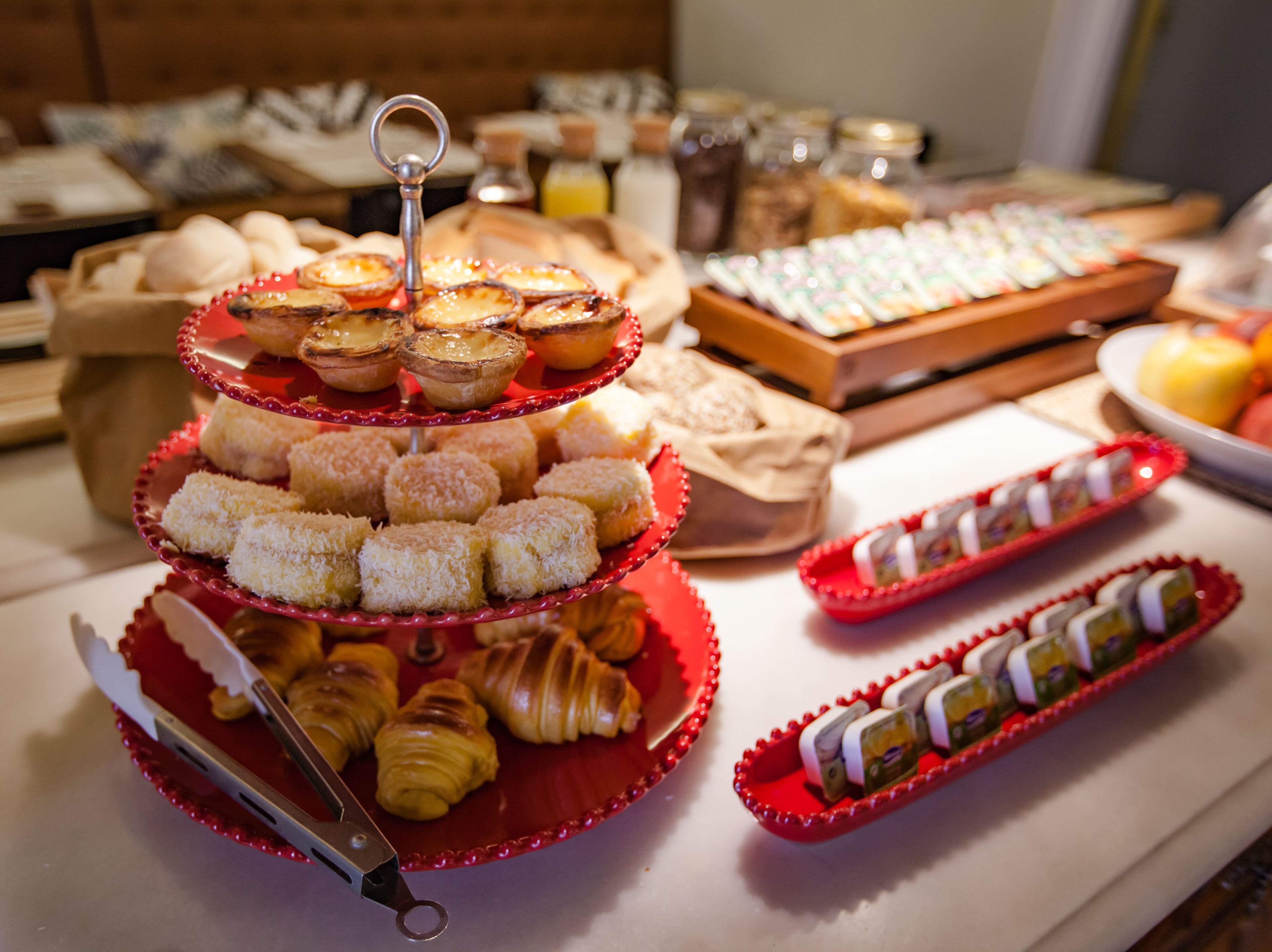 A buffet table with various pastries and desserts, including croissants, tarts, and other baked goods.