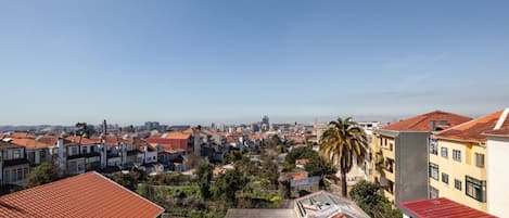 A residential area with red-tiled roofs, a mix of building styles, and a clear sky.