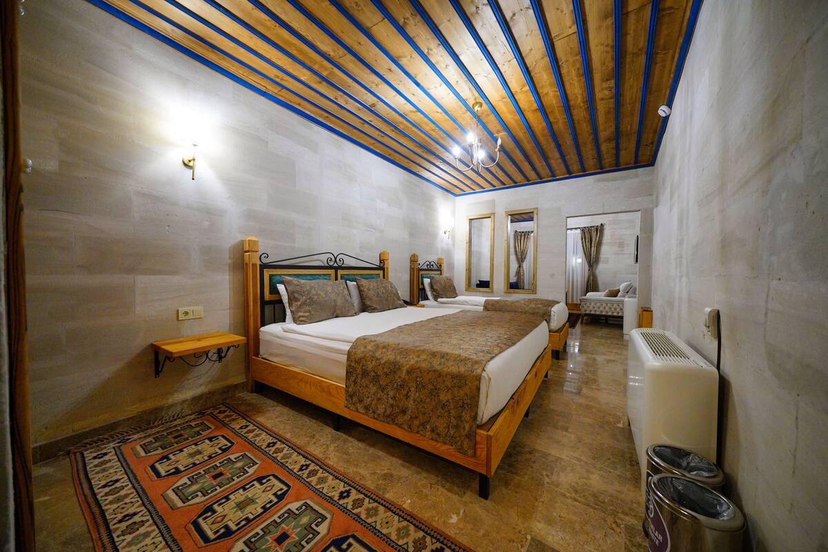 Ein Schlafzimmer mit einem hölzernen Bett, einem Nachttisch, einem Teppich und einem Wandheizkörper.
