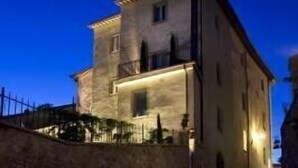 Un bâtiment à deux étages doté d’une façade en pierre, d’un balcon à l’étage supérieur et d’un escalier menant à l’entrée.