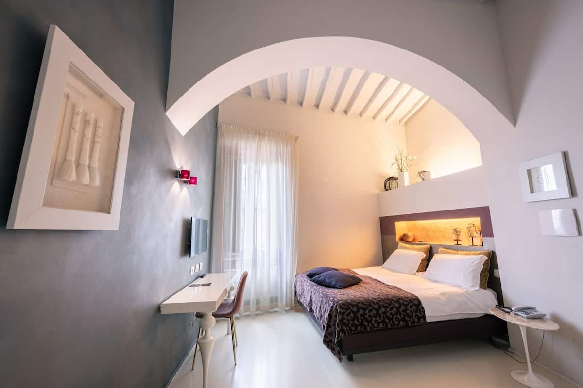Une chambre à coucher moderne avec un lit, une table de chevet et un bureau.