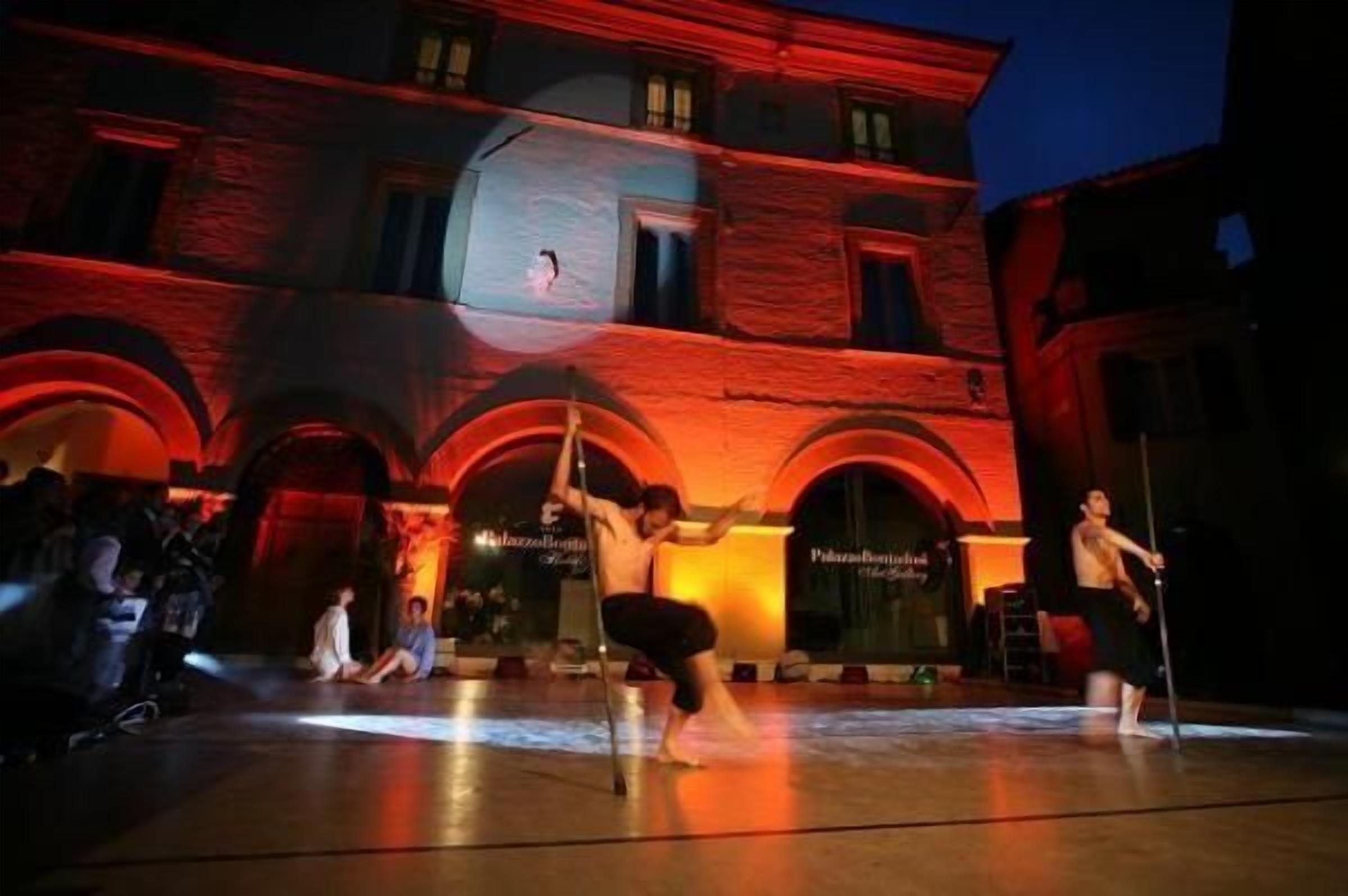Une représentation de danse en plein air, avec un bâtiment en arrière-plan.