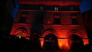 A building with a red-lit facade and multiple arches.