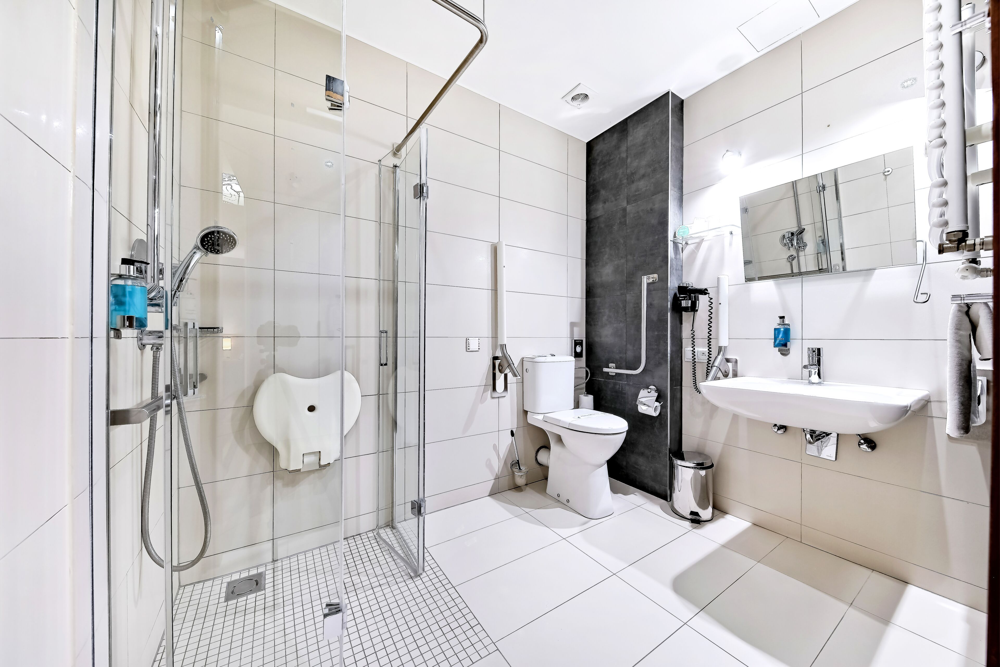 Un baño moderno con ducha envuelta en vidrio, inodoro y lavamanos.