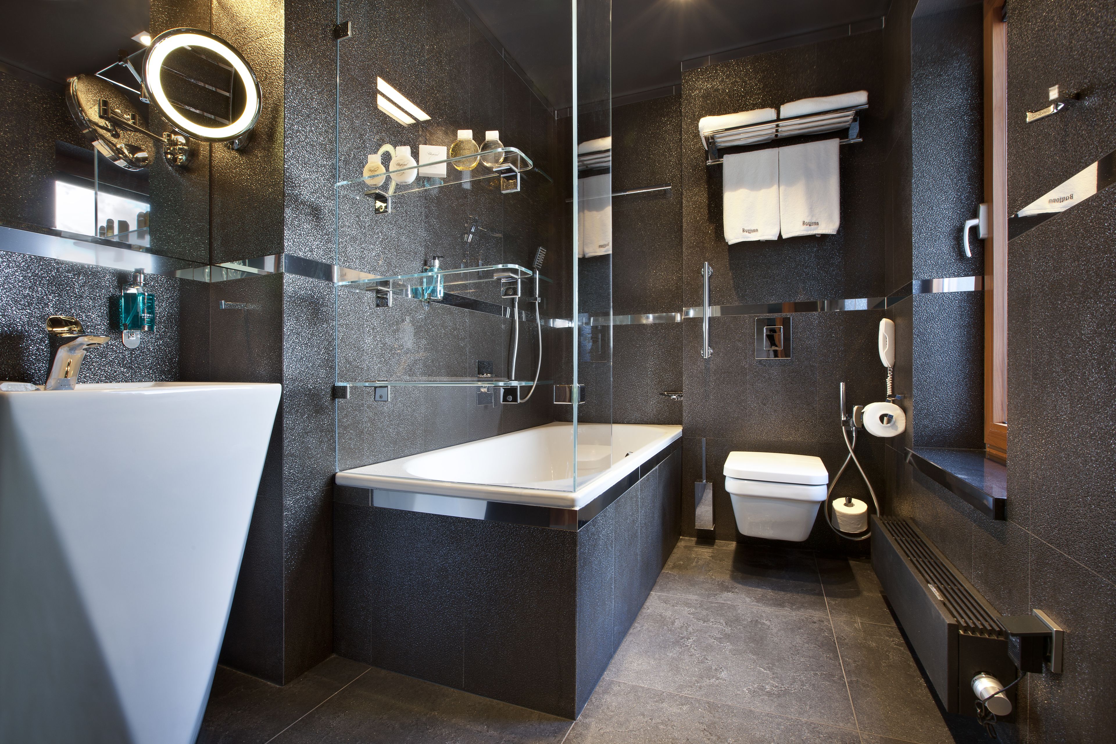 A modern bathroom with a glass-enclosed shower, a standalone bathtub, and a toilet.