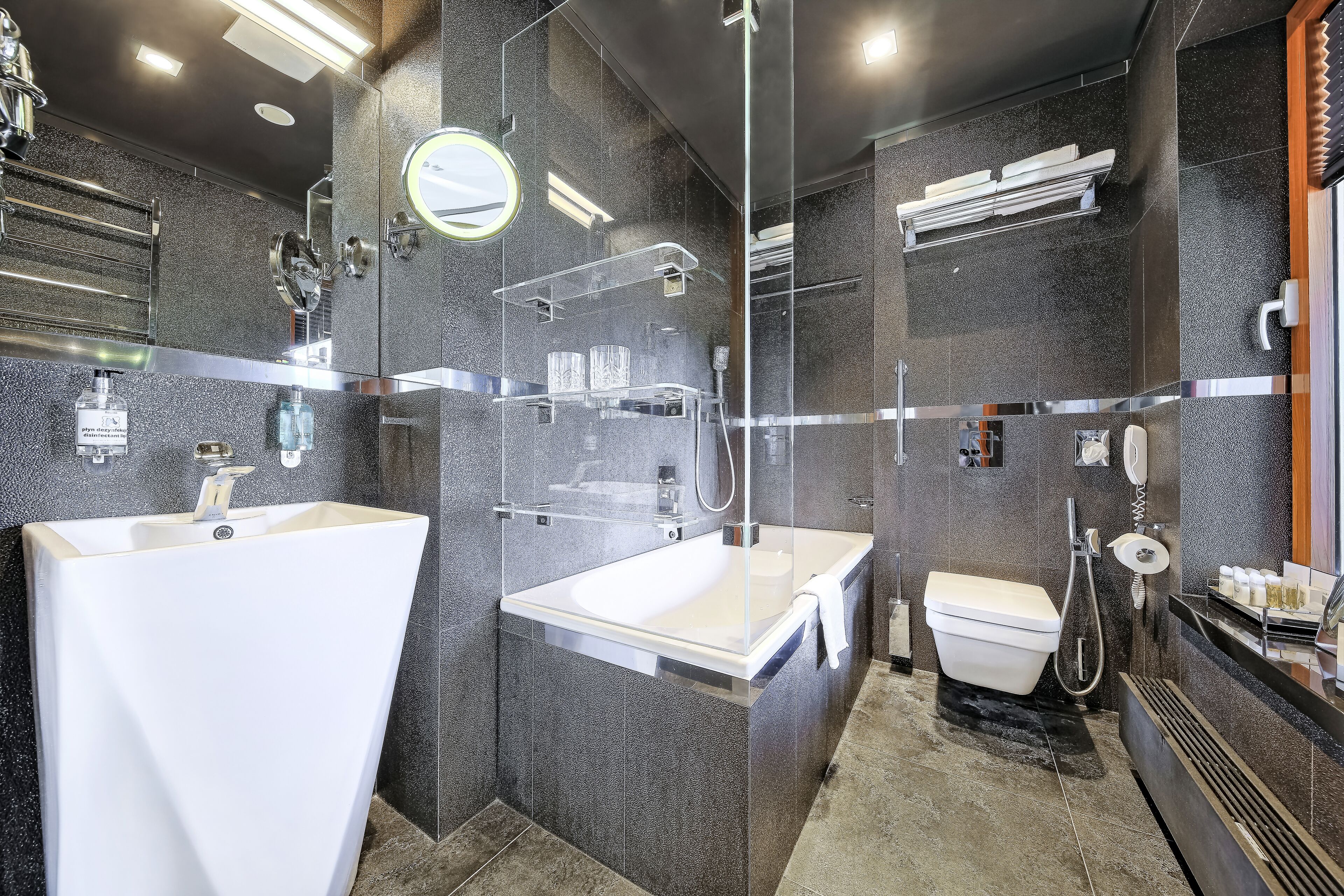 Een moderne badkamer met een ruime badkuip, een apart wastafelmeubel en een douchehoek.