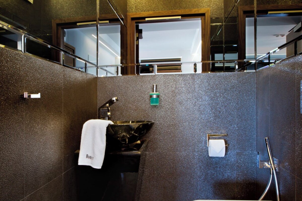 A bathroom with a sink, towel, and a mirror.