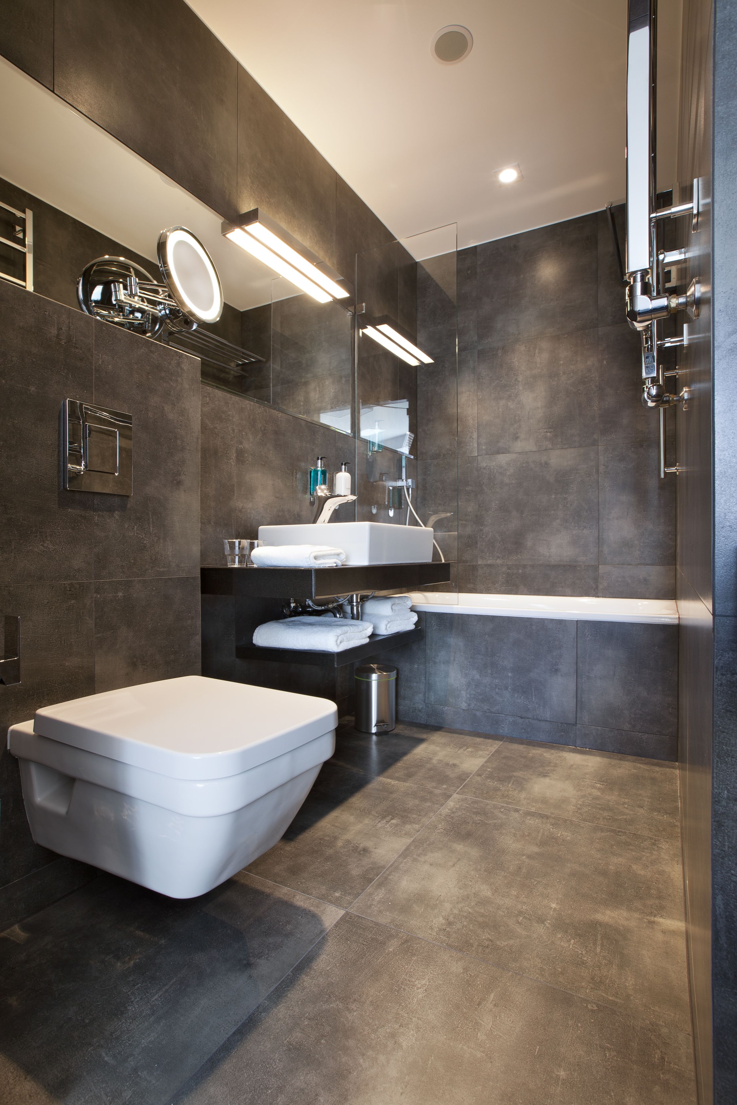 A modern bathroom with a toilet, sink, and bathtub.