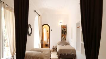 Une chambre avec deux lits, un grand miroir et un tableau au mur.