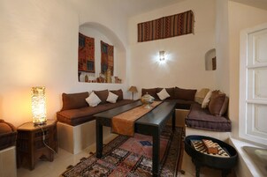 Un salón acogedor con un sofá, una mesa de centro y un tablero de ajedrez.