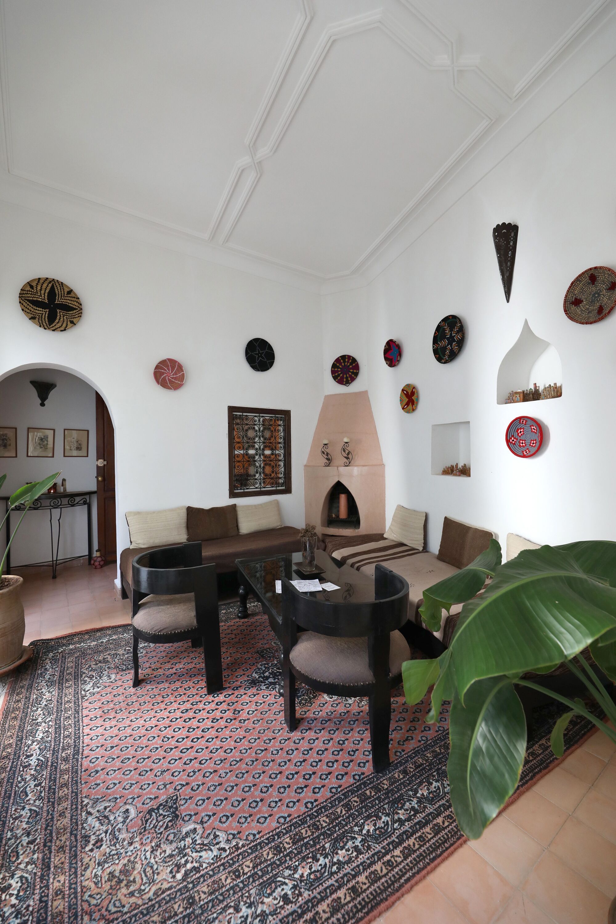 A living room with a sofa, chairs, a coffee table, a fireplace, and various wall decorations.