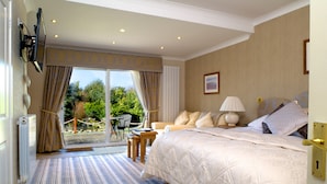 Une chambre d’hôtel dotée d’un grand lit, d’un coin salon avec une table et des chaises, et offrant une vue sur l’extérieur.