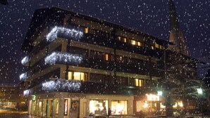 A multi-story hotel with illuminated balconies and a ground-level shop.
