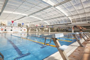 Piscine intérieure, piscine extérieure en saison, chaises longues
