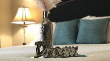 Een bed met een decoratieve fles en veer, en het woord 'Dream' erop.