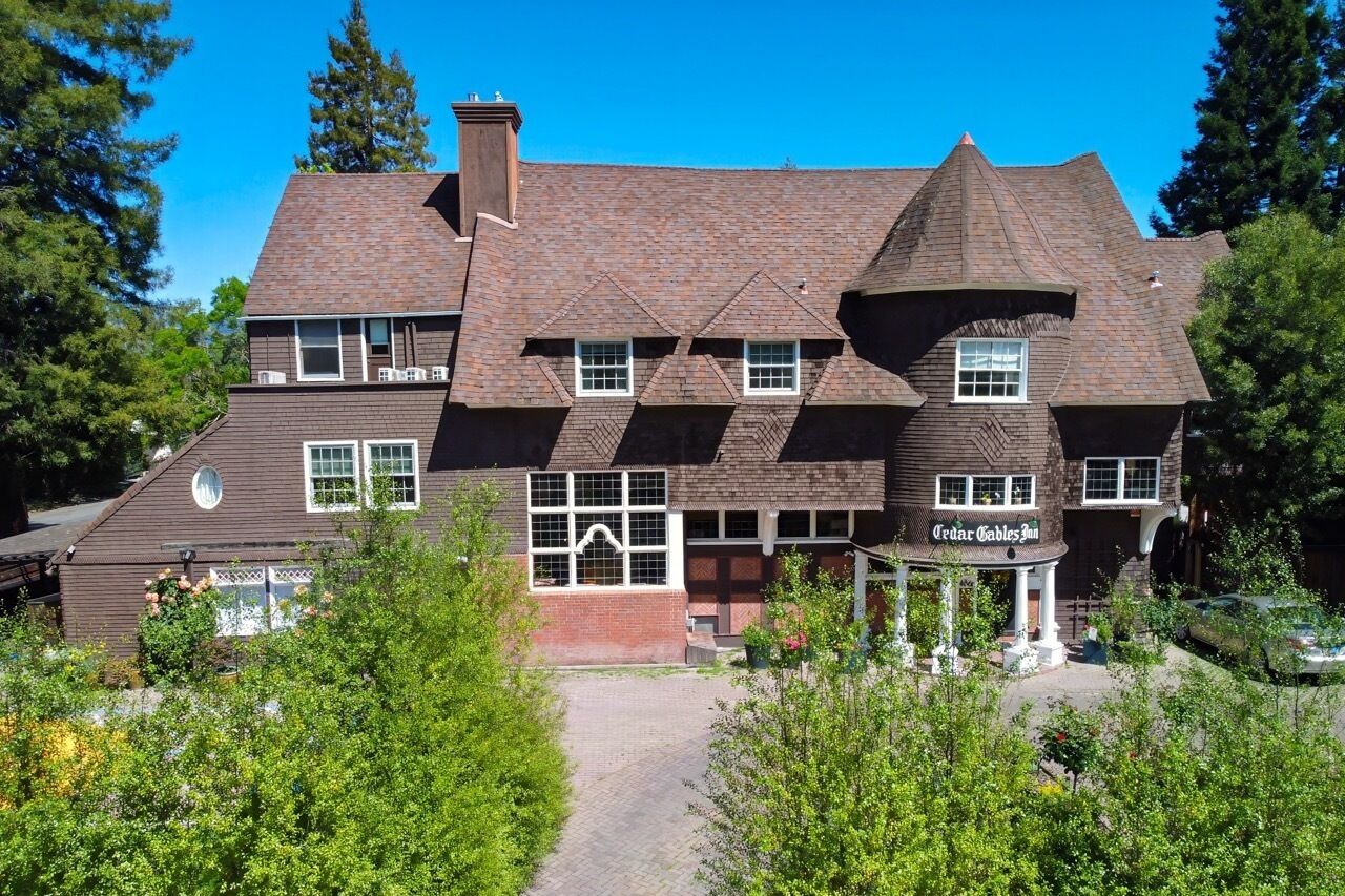 A large, multi-story building with a prominent tower and a covered porch area.
