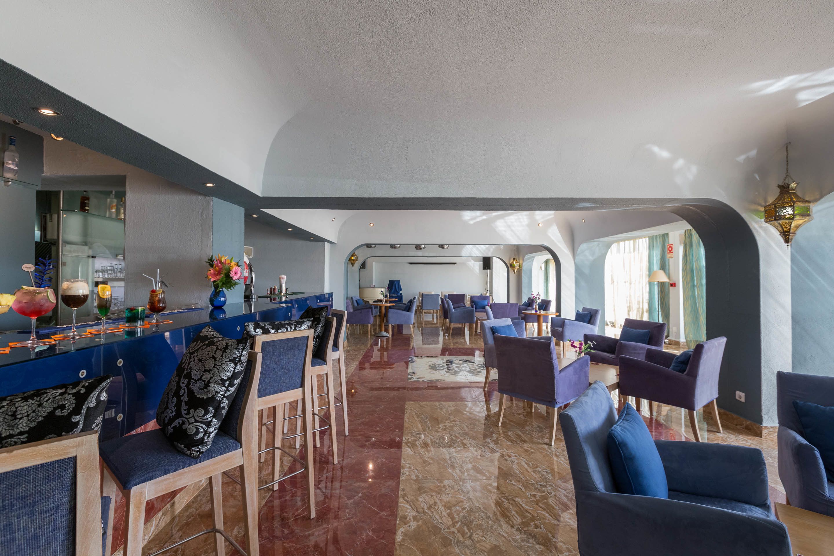 A spacious hotel lobby with a bar area, seating arrangements, and a view of the interior.