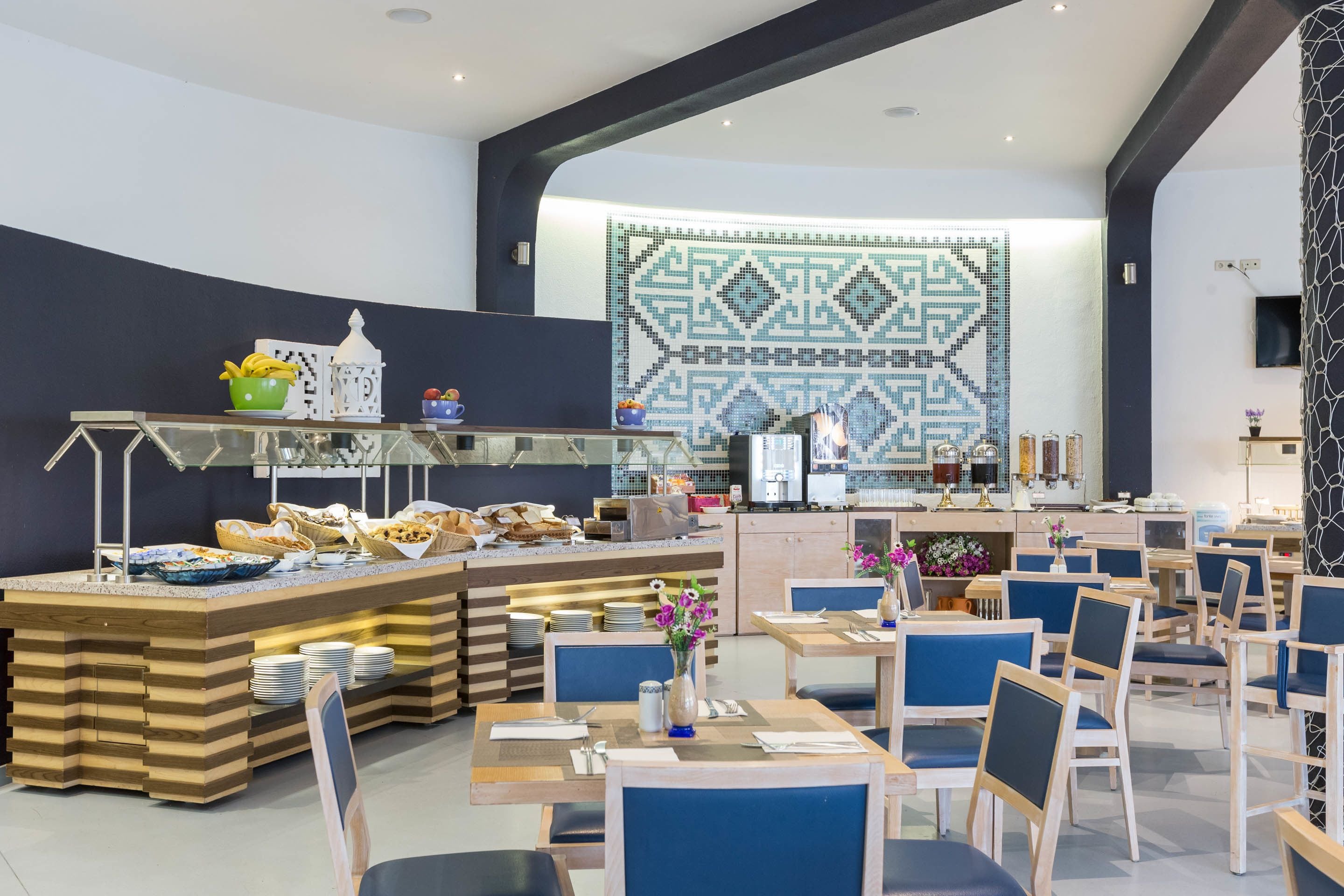 Un comedor moderno con barra libre, que incluye diversas opciones de comida y una pared decorativa.