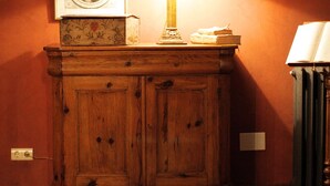 A wooden cabinet with a framed portrait and a lamp on top. - Hotel Casona de Quintana (Soba)