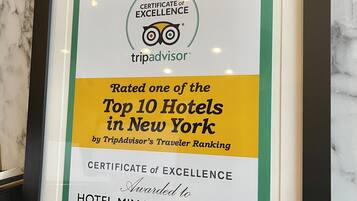 A framed certificate of excellence for Hotel Mimosa New York, rated one of the top 10 hotels in New York by TripAdvisor's Traveler Ranking.