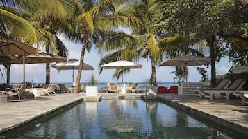 Een buitenzwembad, parasols voor strand/zwembad