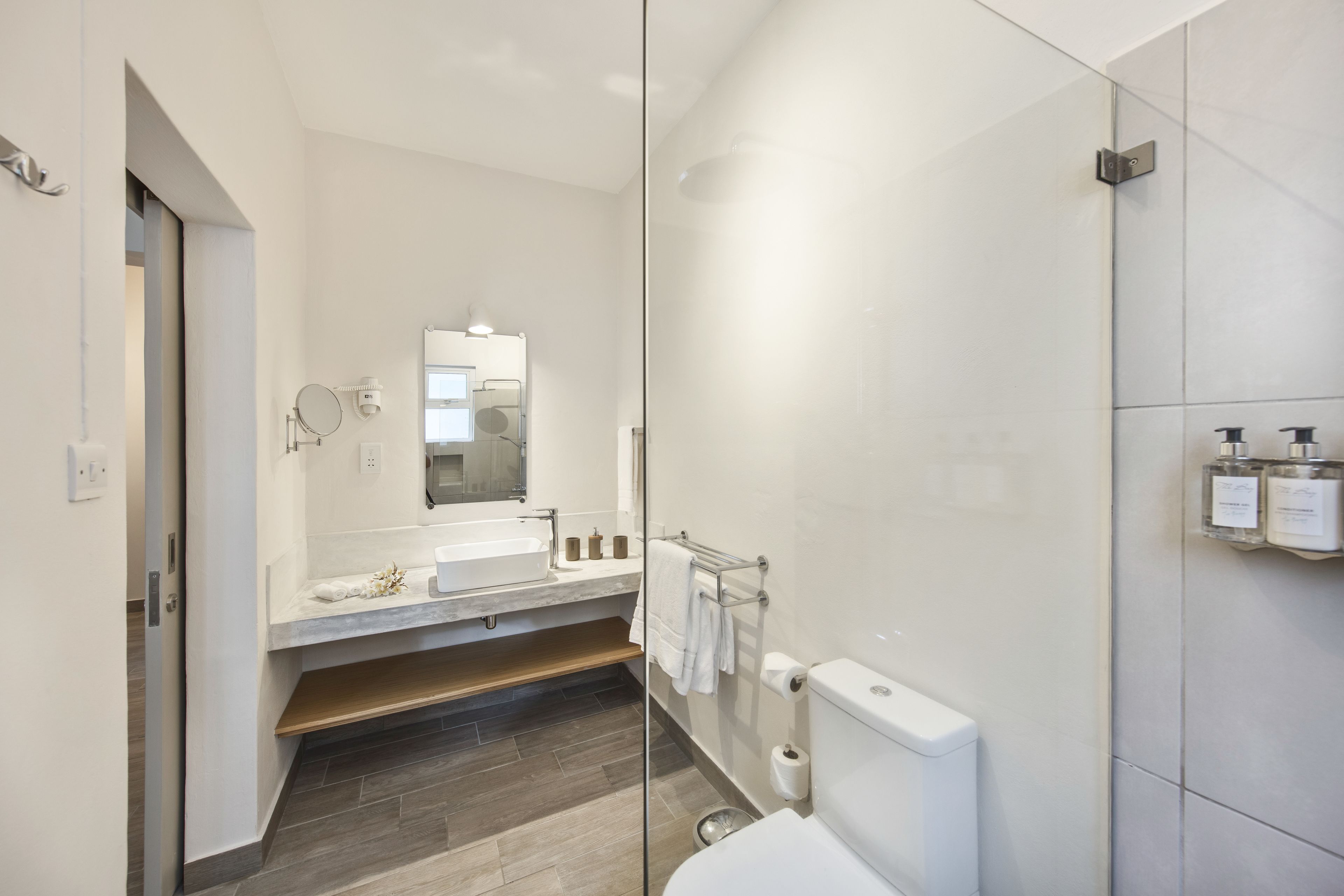 A modern bathroom with a glass shower enclosure, a white sink, and a toilet.