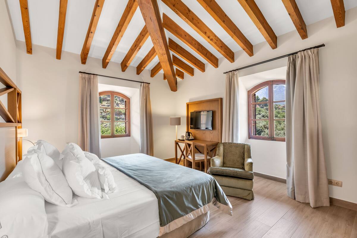 Une chambre à coucher avec un lit, un bureau, une chaise et un téléviseur.