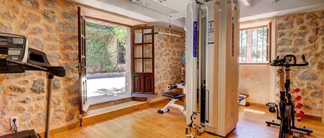 A gym with a treadmill, stationary bike, and weight machine.