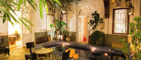 A traditional interior with a tiled bench, seating, and a small table.