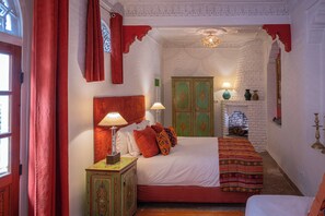 A traditional room with a bed, a nightstand, a green cabinet, and a fireplace. - Riad La Terrasse des Oliviers (Marrakech)