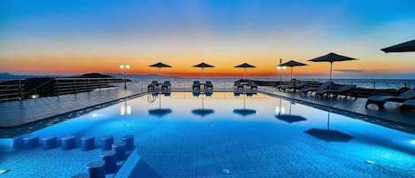 Piscine extérieure, parasols de plage, chaises longues