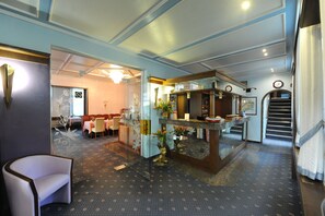 A hotel lobby with a reception desk, seating area, and a staircase. - Hotel Heldt Dependance (Bremen)
