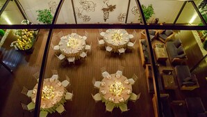 A rooftop dining area with multiple round tables set for guests, surrounded by comfortable seating. - VisPas Hotel (Chisinau)