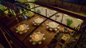 A multi-level dining area with round tables, chairs, and ambient lighting. - VisPas Hotel (Chisinau)