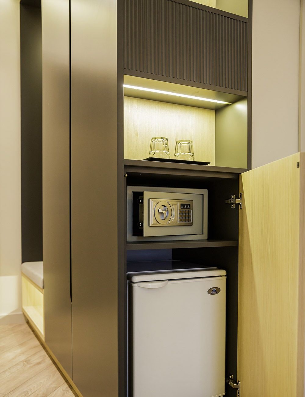 Un minibar compacto con microondas, refrigerador y cristalería.