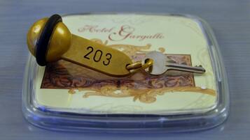 A key with a brass head and a number "203" on a hotel keychain.