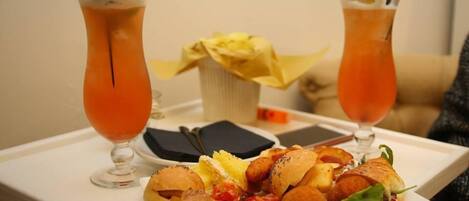 A tray with two drinks and a plate of food.