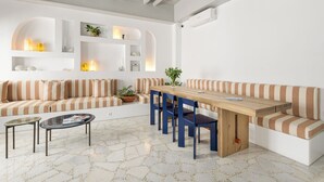 Un salon moderne avec une table à manger en bois, des canapés à rayures et une table basse.
